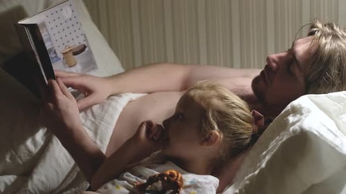 Loving Father Reading Bedtime Story to Young Child