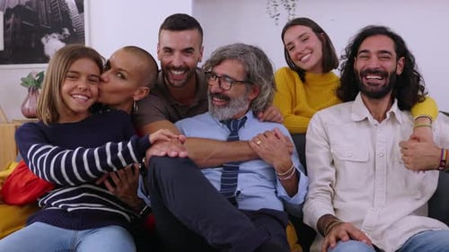 Smiling Family and Friends Sitting Together on Couch