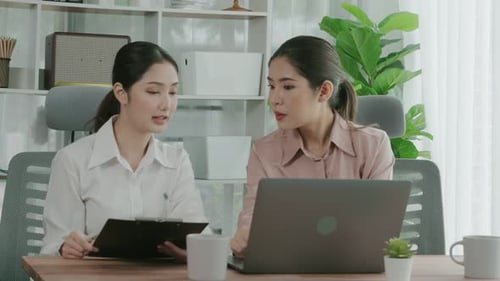 Two Young Enthusiastic Businesswoman Working Together in the Office Workspace