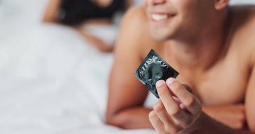 Homme, préservatif et contraception pour la sécurité dans la chambre à coucher, sourire et fierté d'avoir fait un choix responsable à la maison