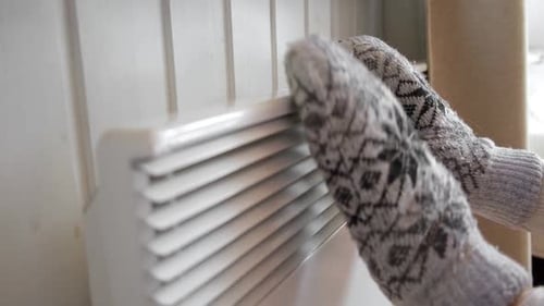Hands in Winter Gloves Warming Up Over Electric Heater Frozen Woman Wearing a Knitted Mittens