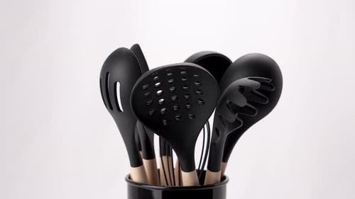 Video of a collection of kitchen utensils, including a spatula, whisk and ladle, arranged in a sulfu