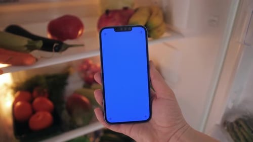 Hand Holding Phone with Chroma Key in Front of Fridge