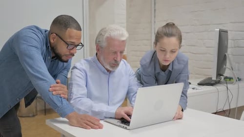 Colleagues Collaborating on Laptop in Office Setting
