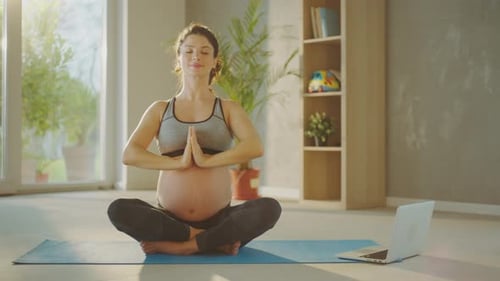 Pregnant Woman Practicing Yoga at Home in Sunlight