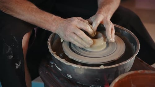 Der Keramiker verwendet eine Töpferscheibe und stellt ein handgemachtes Tonprodukt her