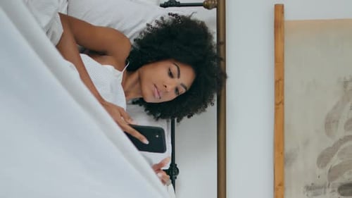 Gentle Model Reading Smartphone Bedroom African Lady with Cellphone Vertically