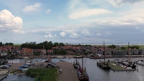 Aerial view of a charming Dutch harbor town with traditional red-roofed houses, moored sailboats