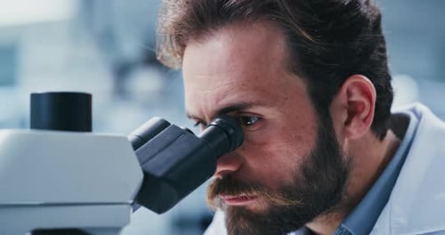 Lab, scientist and man with microscope, study and analysis for vaccine, serious