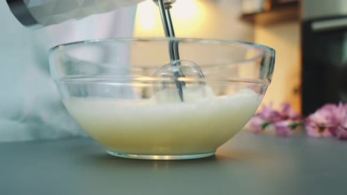 Electric Mixer Whisking Ingredients in a Clear Bowl