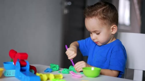 Child Concentrating on Playdough Activity Indoors