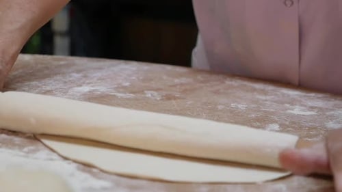 Chef Rolling Dough with Rolling Pin in Bakery