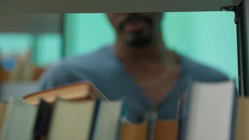 Close Up Of Person Selecting Book From Shelf