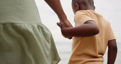Mother, kid and holding hands on beach for support, bonding and holiday with closeup