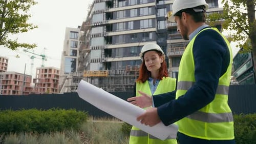 Construction Workers Discussing Plans at Building Site