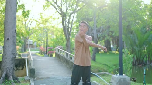 Asian senior elderly man stretching body before exercise in the garden.