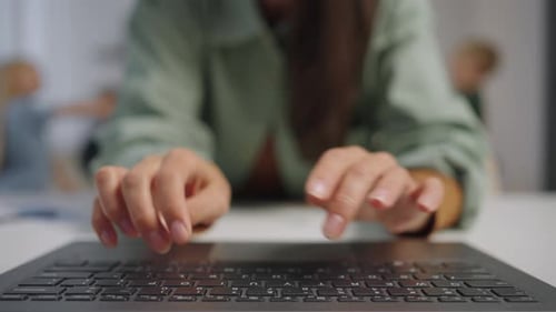 Fingers Typing on Laptop Keyboard in Office