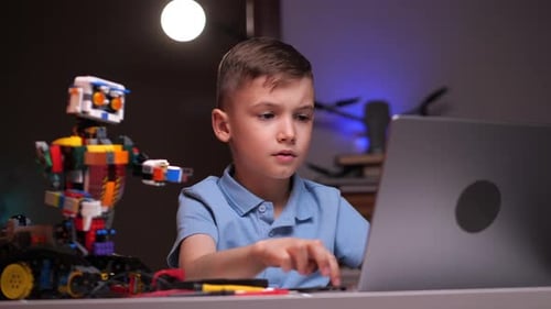 Robot de programación Focused Boy en computadora portátil