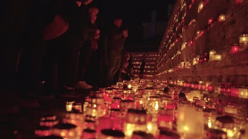 Un rassemblement à Riga avec des chandeliers rouges illuminant la scène