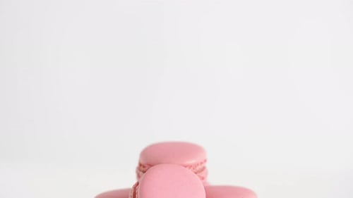 Pink macarons stacked deliciously on a glass stand sweet food still life