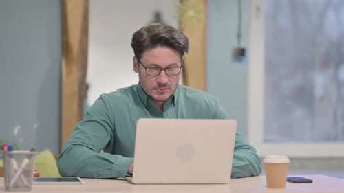 Man Working on Laptop at Desk