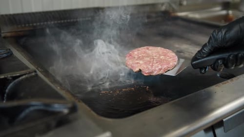 Burger Patty Cooking on a Grill with Steam