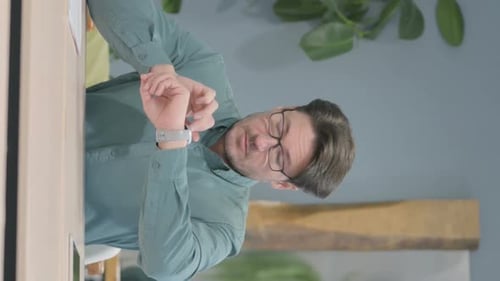 Vertical Video of Man Using Smartwatch at Work
