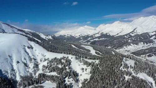 Air flight through mountain clouds over beautiful snow-capped peaks of mountains and glaciers.