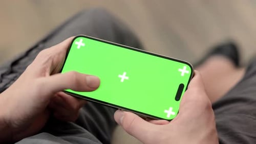 Hands Using Phone with Chroma Key Green Screen at Home Advertising Apps Games or Online Shopping