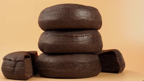 Rotating dark vegetarian donut on an orange background.