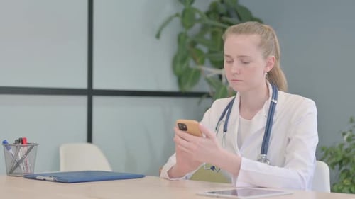 Female Doctor Using Smartphone in Clinic