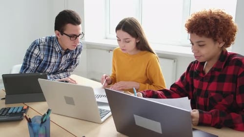 Colleagues Collaborate on Project Using Laptops