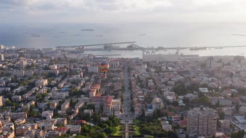 Hot air balloon above Haifa bay and Downtown area at sunrise, Aerial view