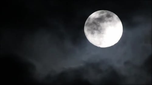 Thin layers of clouds rolling past full moon, moon & clouds very bright. Clouds extremely thin on th