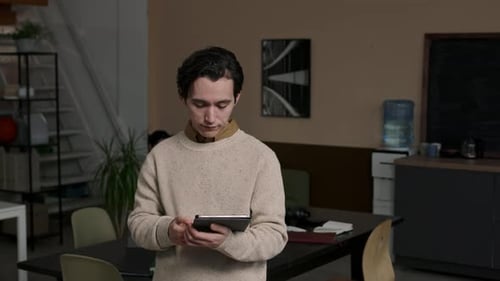 Portrait of Young Male Programmer with Digital Tablet in Office