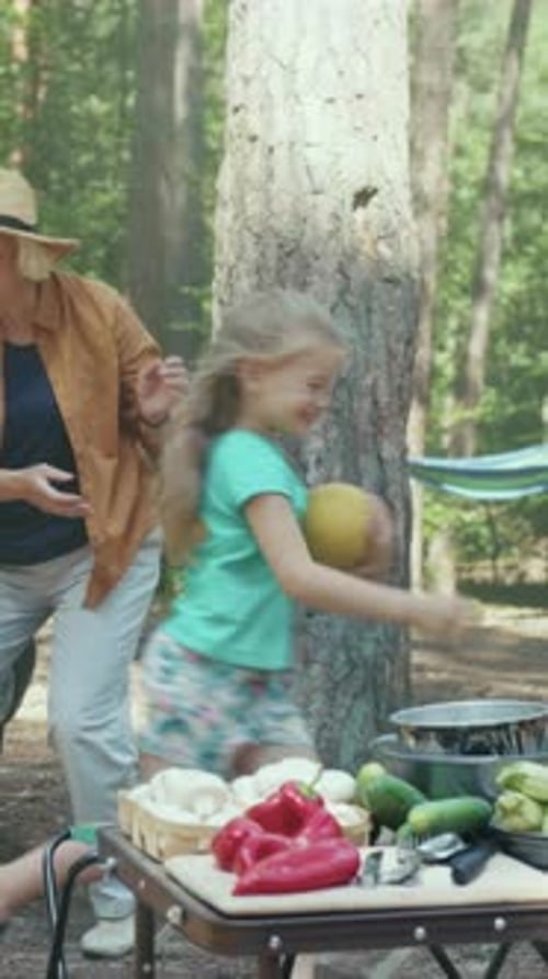 Girl and Senior Woman Unpacking Food at Campsite