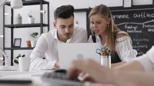 Trendy caucasian entrepreneurs discuss mobile technology startup strategy in loft studio