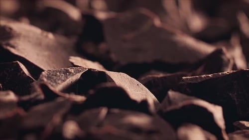Chunks of sweet dark sliding backdrop, close-up. Gourmet dessert ingredient.