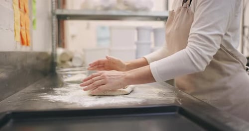 4k video footage of an unrecognizable baker shaping dough in a bakery