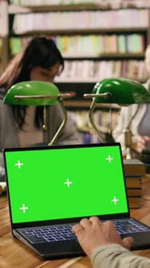 Vertical Video Green Screen Chroma Key on Laptop in Front of Study Group at Library Table