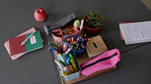 Notebooks, Stationery, and Red Apple on Desk in School Classroom