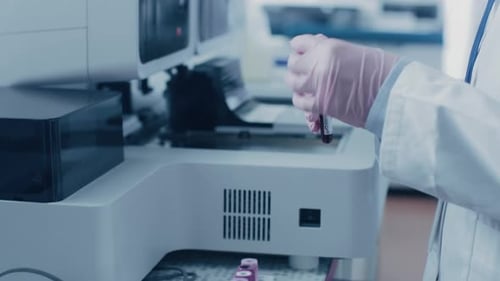 Close-up Female Research Scientist's Hand Takes Test Tube with Blood Sample and Places it Into Medi