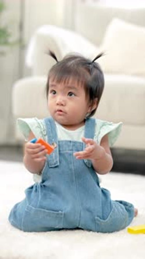 Infant Sitting and Playing with Toys on Rug