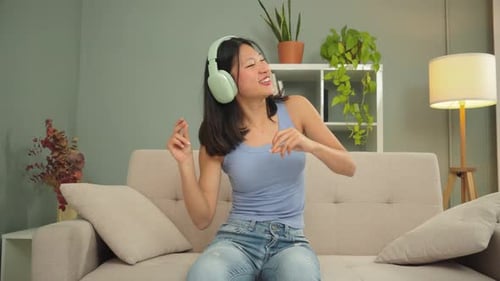 Woman Listening to Music and Dancing on Couch