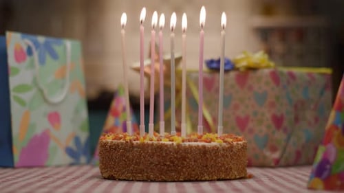 Celebration Cake with Lit Candles and Gifts