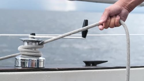 Close Up of Yachtsman Male Hands Holding Rope on Halyard Winch of Sailboat or on Yacht
