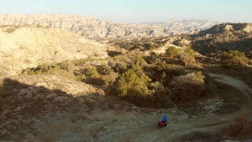 Motorcycle Riding Through Desert Landscape From Above