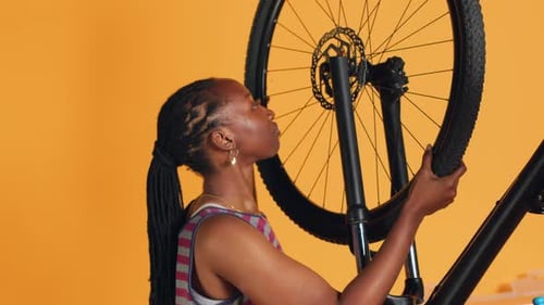 Woman Repairing Bicycle Tire in Studio