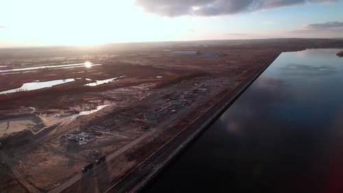 Industrial Territory in Deserted Area on River Bank at Sunset