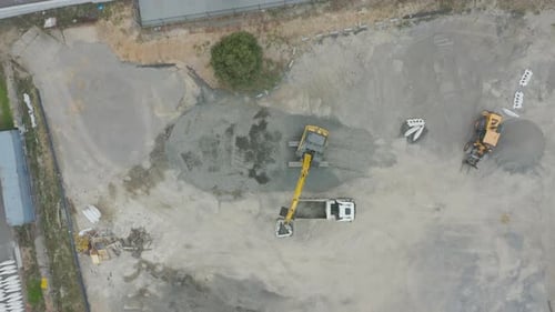 Aerial View of Excavator Loading Gravel into Dump Truck